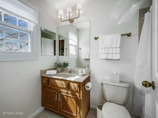 bathroom featuring baseboards, vanity, and toilet