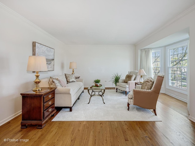 living room featuring baseboards, ornamental molding, and wood finished floors