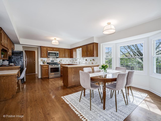 dining space featuring baseboards and dark wood finished floors