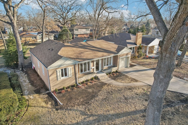 view of front of property with brick siding, concrete driveway, an attached garage, fence, and roof with shingles