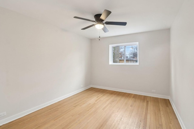 spare room with light wood finished floors, baseboards, and ceiling fan