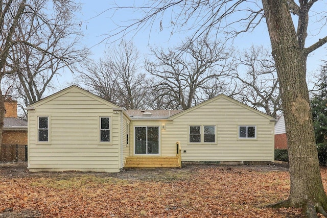 back of house featuring fence and a shingled roof