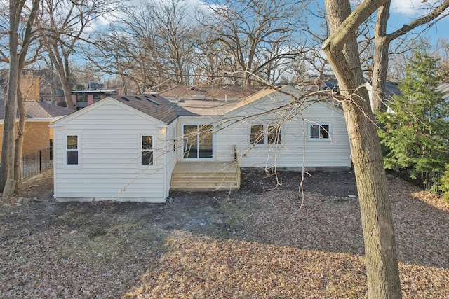 exterior space with roof with shingles and fence
