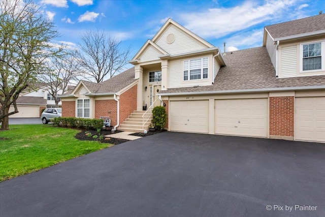 422 Cromwell Cir Unit 2, Bartlett, IL 60103 - view of front facade with brick siding, asphalt driveway, a front lawn, and roof with shingles