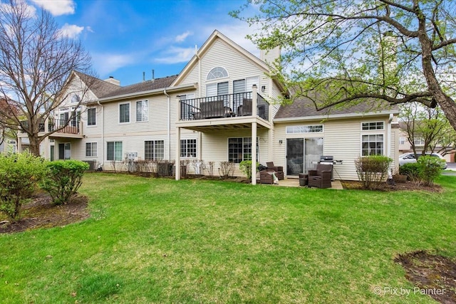 422 Cromwell Cir Unit 2, Bartlett, IL 60103 - back of property featuring a chimney, a balcony, a lawn, a patio area, and an outdoor living space