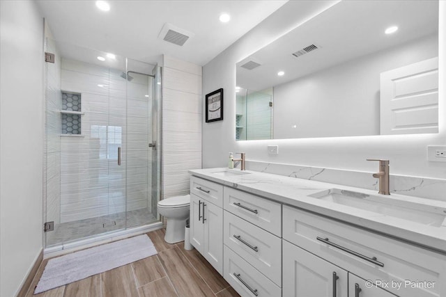 422 Cromwell Cir Unit 2, Bartlett, IL 60103 - full bathroom with double vanity, a shower stall, toilet, wood finished floors, and recessed lighting