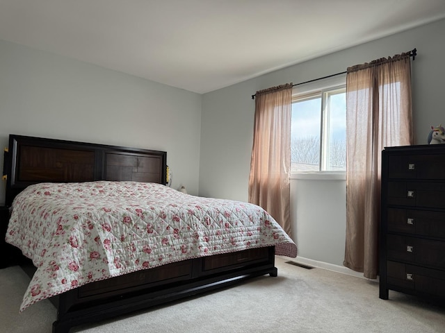 bedroom with visible vents, light colored carpet, and baseboards