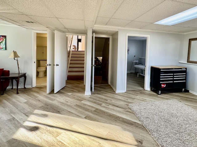 bedroom with a paneled ceiling, visible vents, wood finished floors, and ensuite bathroom