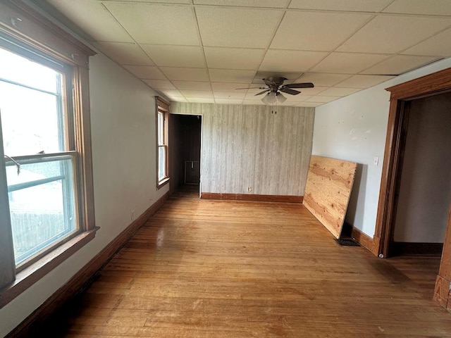 unfurnished room with wood finished floors, baseboards, a wealth of natural light, and a ceiling fan