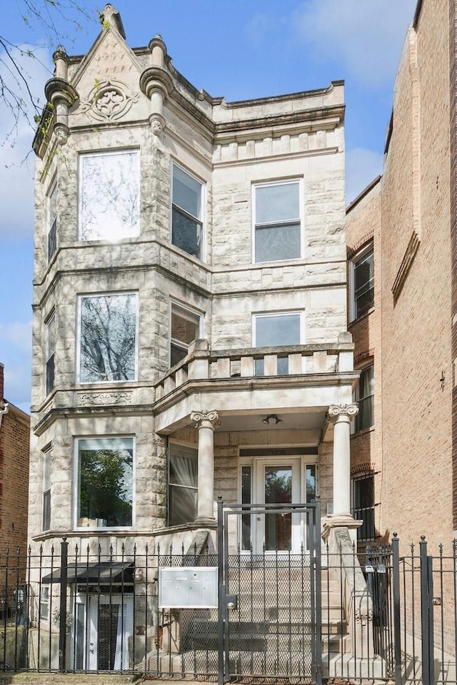 1236 N Campbell Ave Unit G, Chicago, IL 60622 - view of front facade with stone siding, a fenced front yard, and a gate