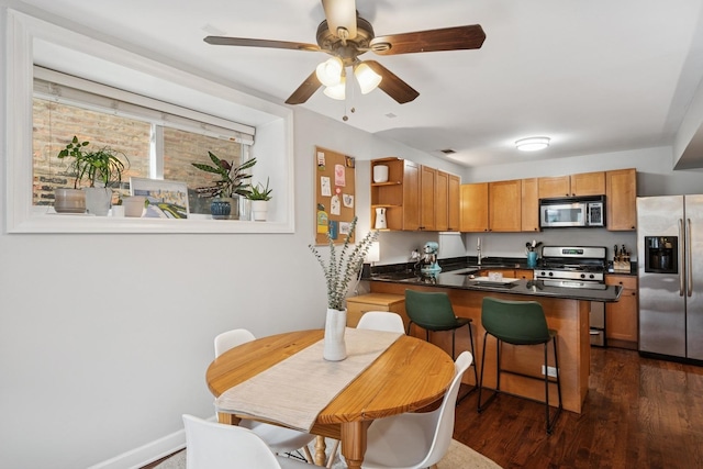 1236 N Campbell Ave Unit G, Chicago, IL 60622 - kitchen featuring a ceiling fan, a peninsula, dark wood-type flooring, dark countertops, and stainless steel appliances