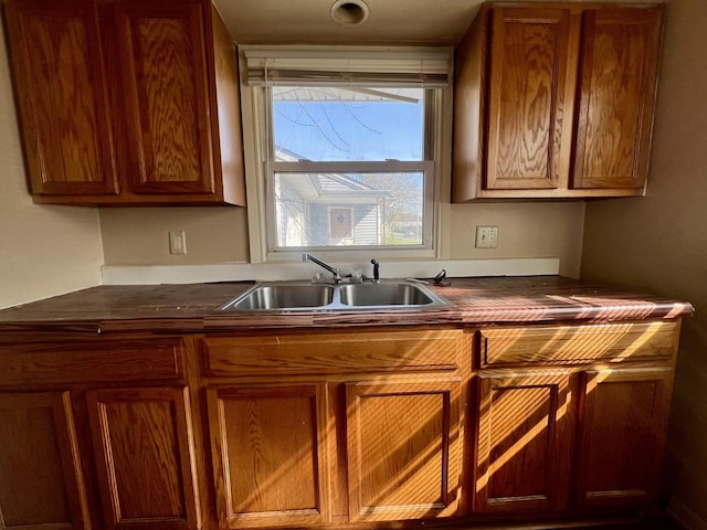 1011 N Coler Ave, Urbana, IL 61801 - kitchen with a sink, dark countertops, and brown cabinetry