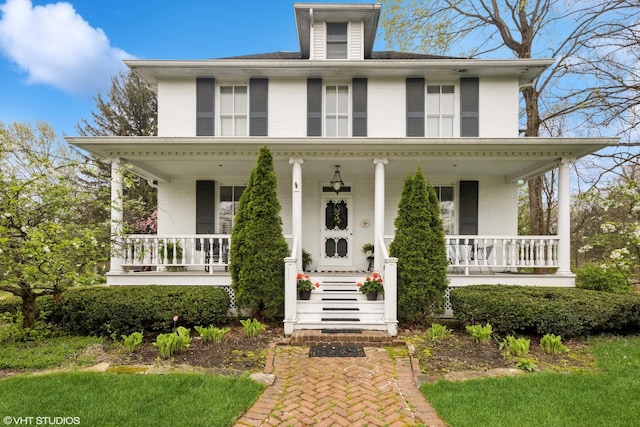 farmhouse-style home with brick siding and covered porch