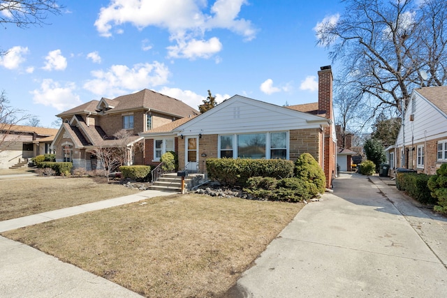 view of front facade with a chimney, a front lawn, and brick siding