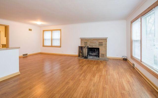 unfurnished living room with visible vents, a healthy amount of sunlight, light wood-style floors, and crown molding