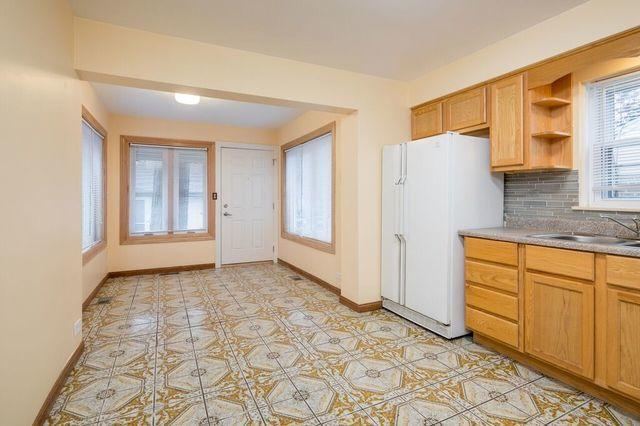 kitchen featuring a sink, baseboards, freestanding refrigerator, backsplash, and open shelves