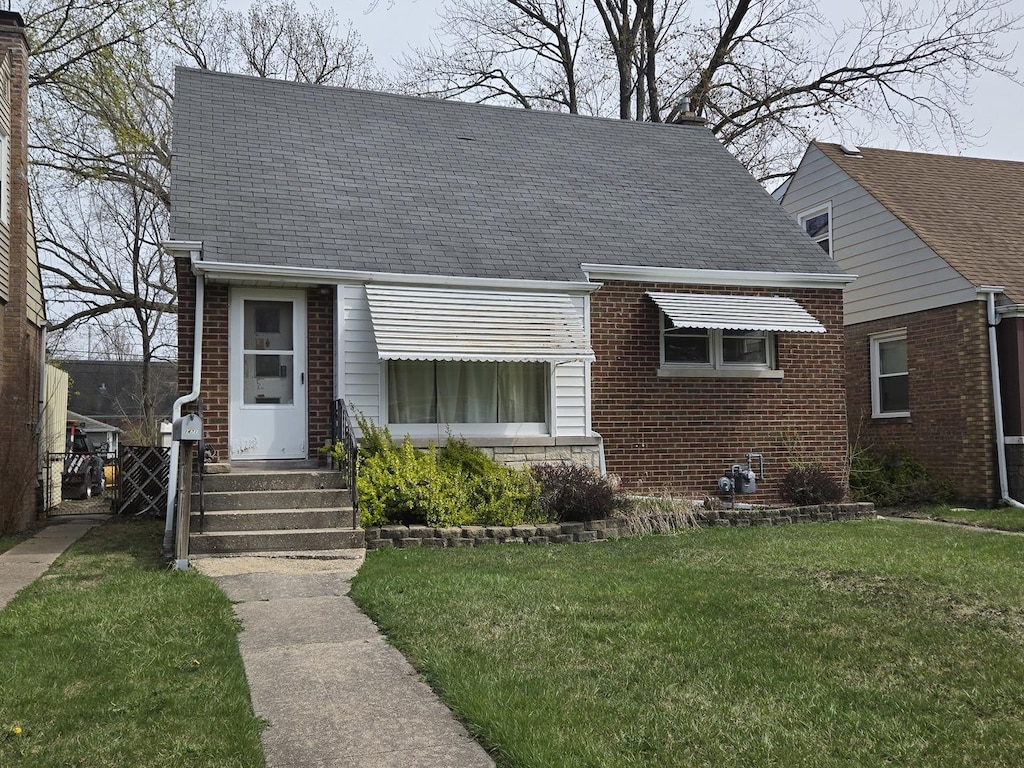 1471 Forest Ave, Calumet City, IL 60409 - view of front of property featuring brick siding, roof with shingles, and a front lawn