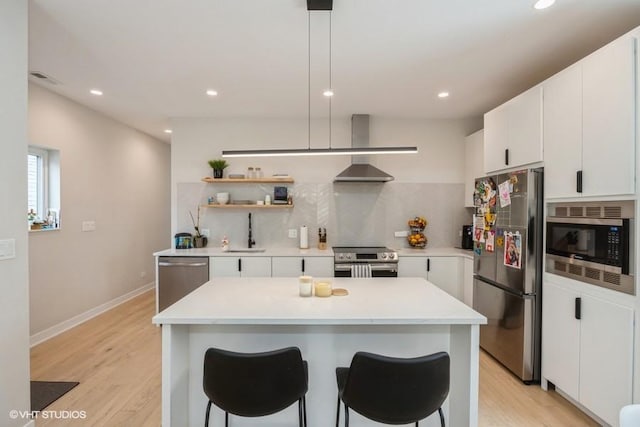 kitchen featuring light wood-type flooring, a sink, tasteful backsplash, and stainless steel appliances