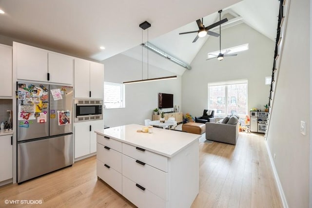 kitchen with plenty of natural light, appliances with stainless steel finishes, high vaulted ceiling, and ceiling fan