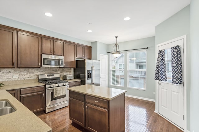 1122 Chelsea Dr, Lake Zurich, IL 60047 - kitchen featuring appliances with stainless steel finishes, baseboards, decorative backsplash, dark wood-type flooring, and pendant lighting
