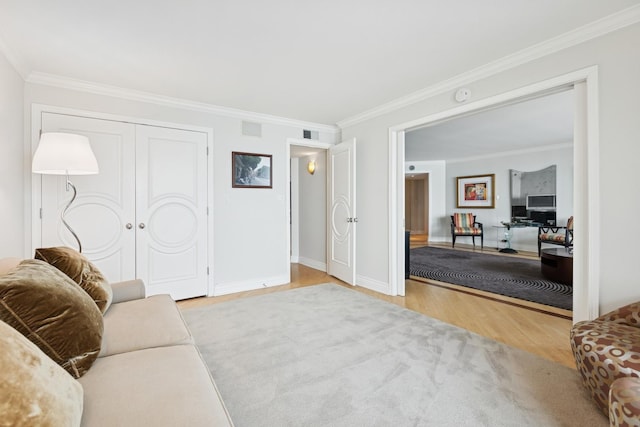 living room featuring baseboards, ornamental molding, wood finished floors, and visible vents