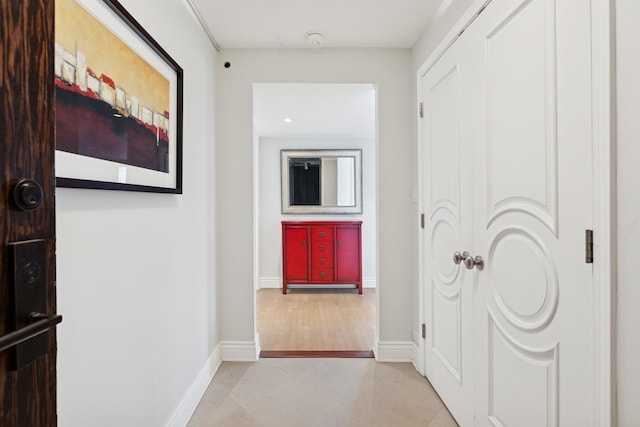 corridor with baseboards and light tile patterned floors