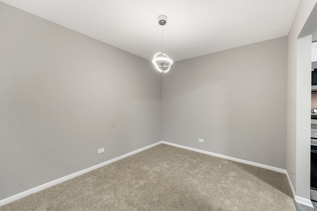 carpeted spare room featuring baseboards