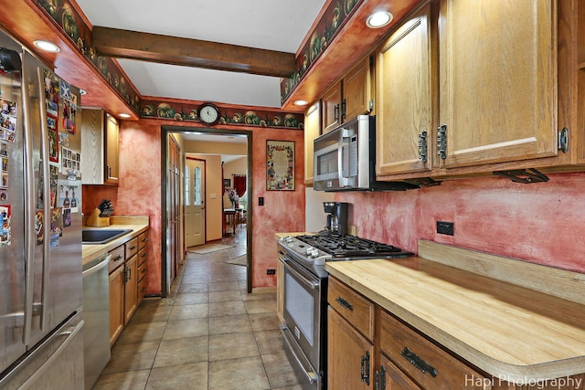 kitchen featuring appliances with stainless steel finishes, brown cabinets, and wood counters