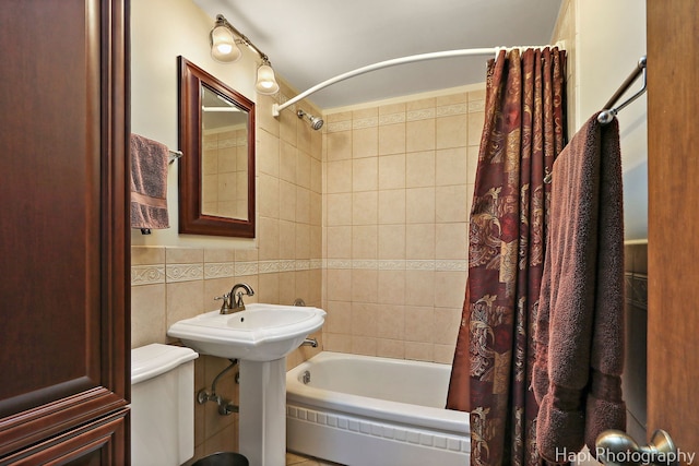 bathroom featuring shower / tub combo, tile walls, and toilet