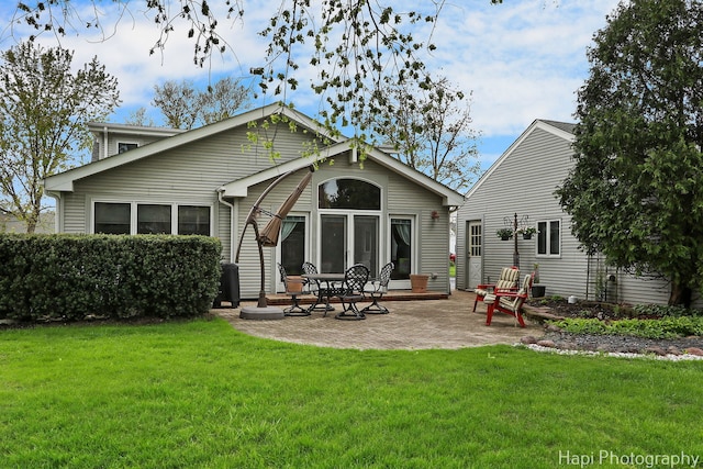 rear view of house featuring a lawn and a patio area
