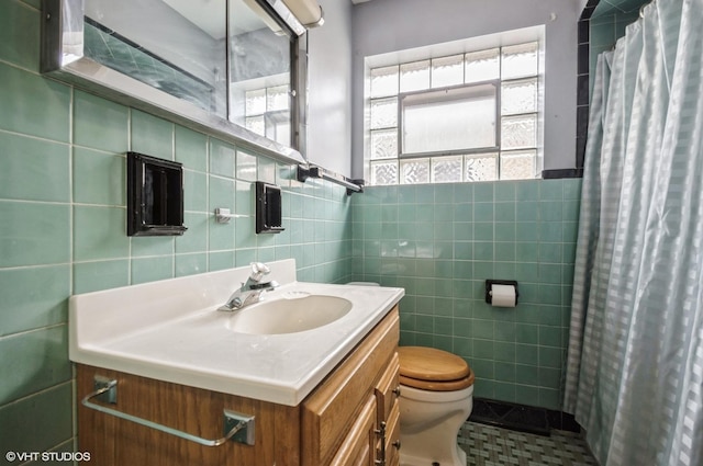 3809 N Sayre Ave, Chicago, IL 60634 - bathroom featuring a healthy amount of sunlight, tile walls, vanity, and toilet