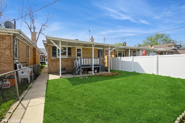3809 N Sayre Ave, Chicago, IL 60634 - rear view of property featuring a lawn, a fenced backyard, and brick siding