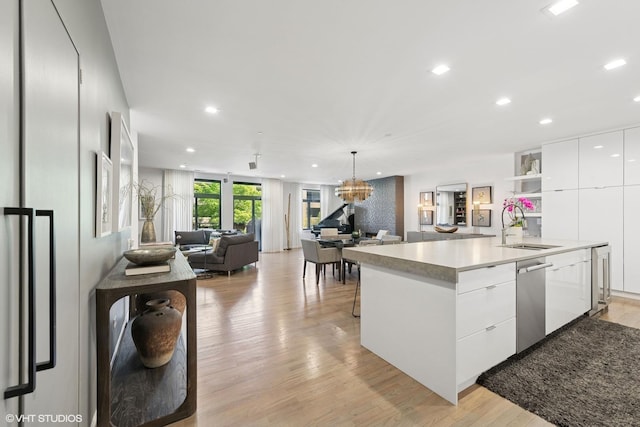 33 W Huron St Unit 309, Chicago, IL 60654 - kitchen with a sink, modern cabinets, stainless steel dishwasher, open floor plan, and white cabinets