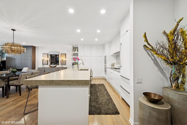 33 W Huron St Unit 309, Chicago, IL 60654 - kitchen featuring modern cabinets, a sink, white cabinets, a breakfast bar area, and recessed lighting