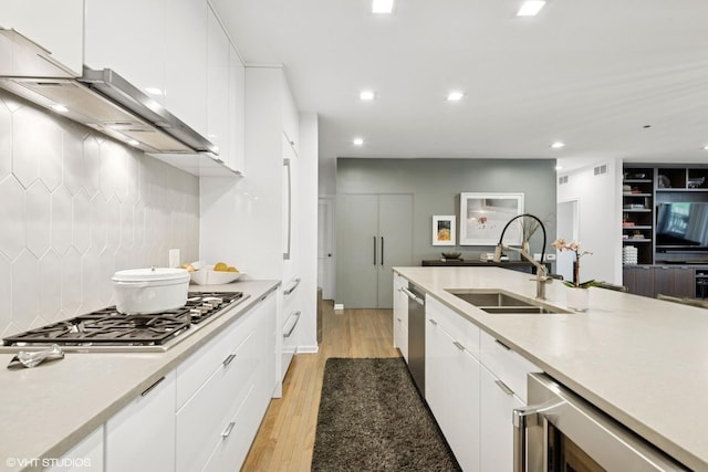 33 W Huron St Unit 309, Chicago, IL 60654 - kitchen with a sink, appliances with stainless steel finishes, wine cooler, light wood finished floors, and white cabinets