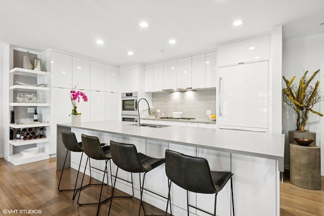 33 W Huron St Unit 309, Chicago, IL 60654 - kitchen featuring modern cabinets, a sink, wood finished floors, white cabinets, and recessed lighting