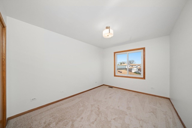 spare room featuring visible vents, carpet flooring, and baseboards