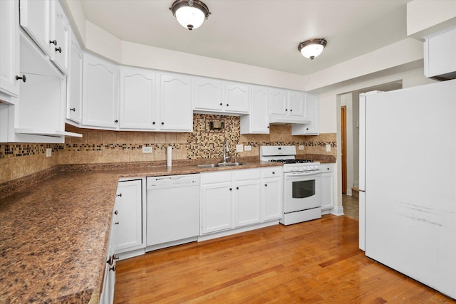 kitchen with white cabinetry, white appliances, decorative backsplash, and a sink