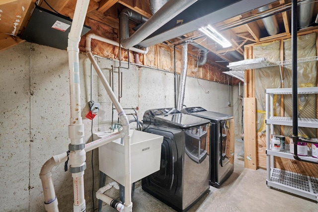 washroom featuring washer and clothes dryer, laundry area, and a sink
