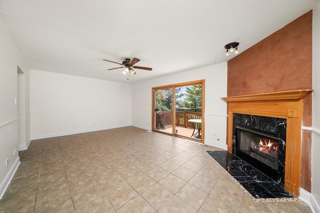 unfurnished living room featuring tile patterned flooring, a ceiling fan, baseboards, and a fireplace