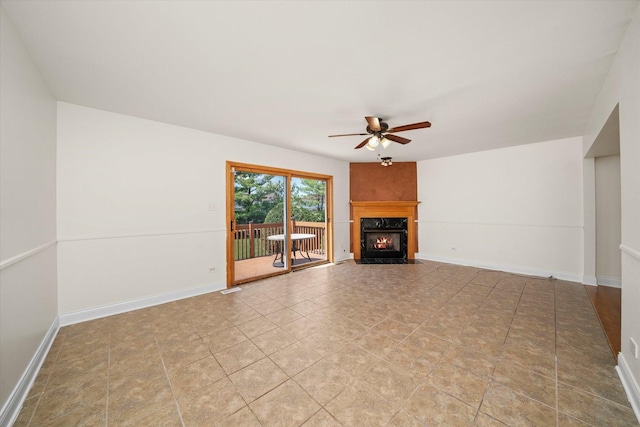 unfurnished living room with ceiling fan, baseboards, tile patterned floors, and a fireplace