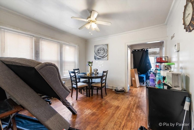 dining room featuring crown molding, light wood finished floors, and ceiling fan