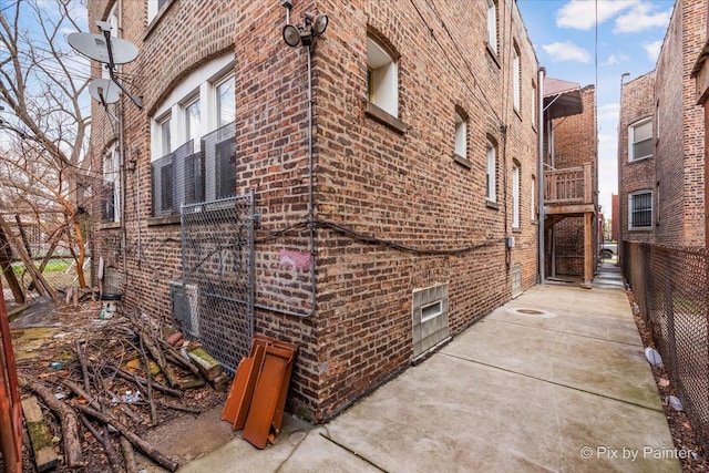 view of home's exterior featuring fence and brick siding