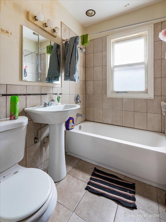 bathroom featuring tile walls, tile patterned floors, shower / washtub combination, and toilet