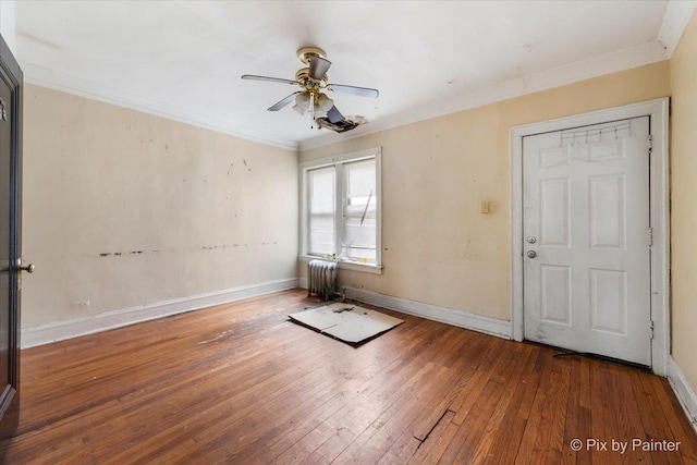 unfurnished room with radiator, wood-type flooring, ceiling fan, and ornamental molding