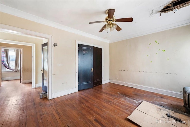 unfurnished bedroom with wood-type flooring, crown molding, baseboards, and a ceiling fan