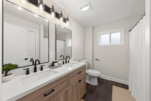 full bath featuring a sink, plenty of natural light, wood finished floors, and visible vents