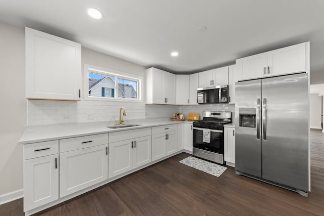 kitchen with a sink, dark wood finished floors, white cabinets, and stainless steel appliances