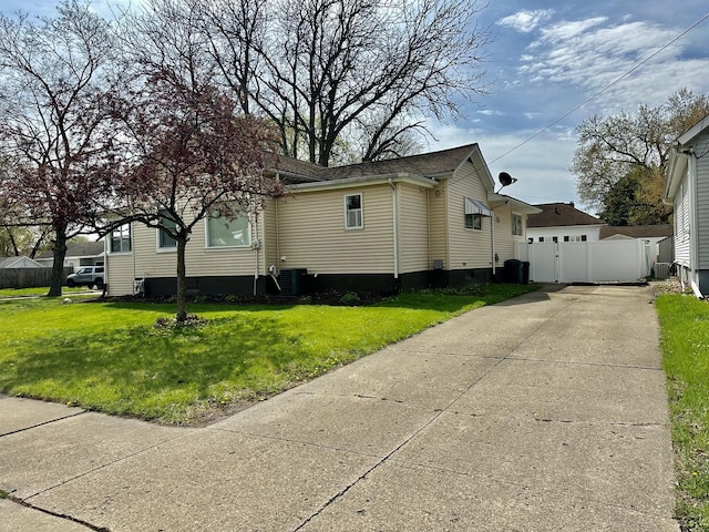 view of front of house with fence, a front lawn, cooling unit, and concrete driveway