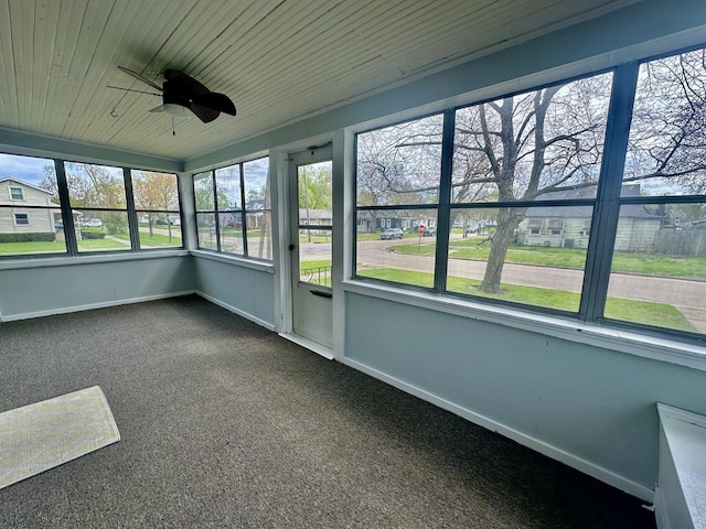 unfurnished sunroom with ceiling fan